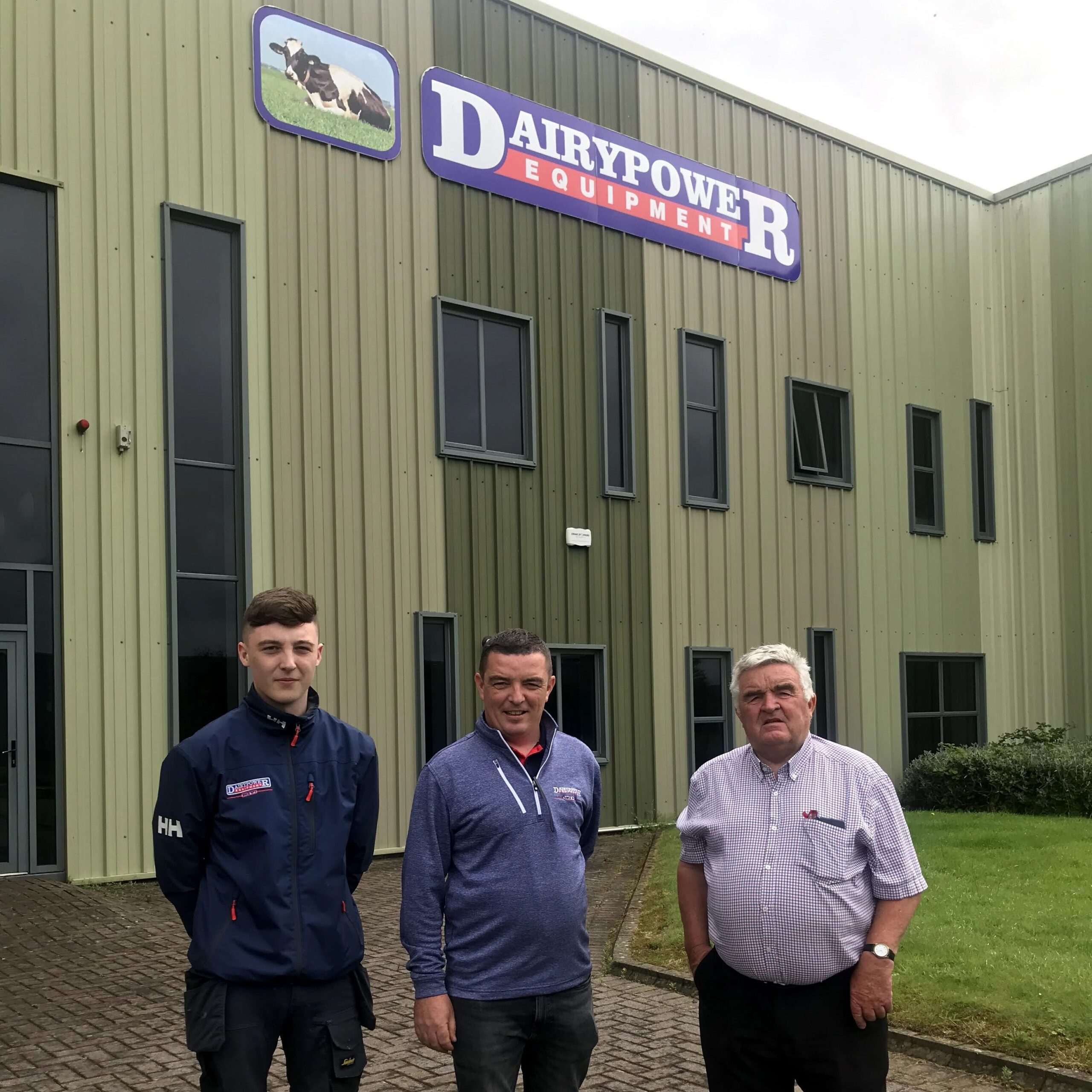 Dairy Power headquarters building with three people who work there in the foreground