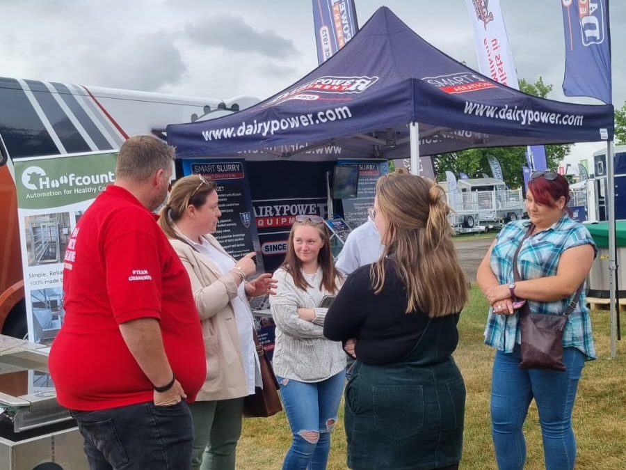 six people standing in front of the Dairy Power tent at the Great Yorkshire Show